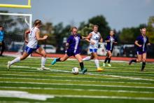 Grace Meyer concentrates on passing the ball up the field.  Photo by Peterman Sports Photography • photoman@iw.net