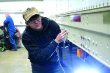 Hayden Smith places new bolts into the trailer to help reinforce the flooring. Photo by Beth Sherard-Hutcheson times1reporter@gmail.com
