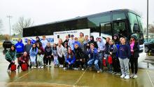 Despite the rainy conditions, the Elk Point-Jefferson Marching Band members are all smiles before they get on a charter bus to head off to Tampa, FL to play during halftime of the ReliaQuest Bowl. Photo courtesy of Emily Wells
