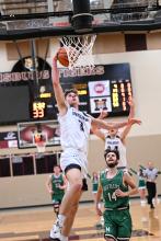 Senior Isaac Bruns goes in for a dunk against the Miller Rustlers. Photo courtesy of Squier Designs