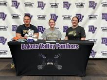 Emily Carlson, middle, signed with Nebraska Weselyan University to participate in their swimming program. She was surrounded by her parents, Mark and Susan Carlson, and other family members and friends when she signed April 28. Submitted photo
