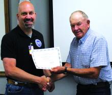 Union County Emergency Manager Jason Westcott receives his certificate of completion to become a Certified Emergency Manager from Union County Commissioner Chairman Milton Ustad. The certificate came from the South Dakota Emergency Management Association. Photo by Beth Hutcheson • times1reporter@gmail.com