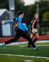 Jaelyn Bacan makes a stop at the goal and kicks the ball away to one of her teammates.