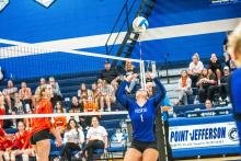 Courtney Brewer sets the ball to one of the Husky hitters.