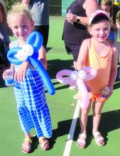 Adlie McCabe-Bledsoe and Madison Mousel show o_ the balloon animals they received at the fall festival on Oct. 1.