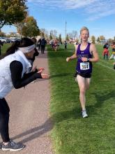 Dakota Valley Head Cross Country Coach Tiffany Wendling cheers on Blake Schmiedt as he runs in a meet in 2021. She was named the 2023 Coach of the Year by the South Dakota Cross Country and Track and Field Coaches Association. Submitted photo