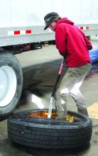 Tracen Pearson works to take a tire off of the rim. Pearson is interning at Helluva and learning different tricks in the trade. One of the projects he’s currently learning is how to replace tire rims on semi-trailers. Photo by Beth Hutcheson • times1reporter@gmail.com