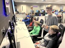 Nathan Rathgeber (far left) and Landon Greene (right) provide Esport instructions to middle school campers on Jan. 6. Submitted photo