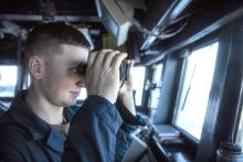 Ensign Samuel Wente, from North Sioux City, SD, uses binoculars to scan the horizon for contacts on the bridge of Arleigh Burke-class guided-missile destroyer USS Sterett (DDG 104). Sterett, assigned to Carrier Strike Group ONE, is deployed to U.S. 7th Fleet area of operations in support of a free and open Indo-Pacific. U.S. Navy photo by Mass Communication Specialist 1st Class Charles J. Scudella III