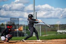Brandon Benett hits hard in the wind against Vermillion on May 2. Photo by Peterman Sports Photography • stevepeterman5@gmail.com