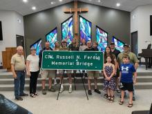 The CPL Russell N. Ferdig Memorial Bridge sign with his family. Submitted photo