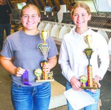 Regan Rasmussen, seen here on the left, poses with her Senior Showmanship award from the Fair.