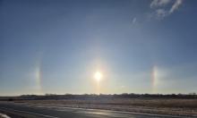 A pair of rainbow‑hued sundogs flank the sun over a rural road near Elk Point, S.D., on Dec. 29, 2025. The colorful optical display, caused by sunlight refracting through ice crystals in the upper atmosphere, is known as a parhelion. Sundogs often appear on cold, clear mornings when the sun is low on the horizon. Photo by Shannon Jost • timesleader1@gmail.com