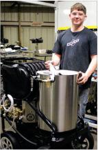 Noah Thooft works on the cylinder to the pressure washer. He then used a hoist to lift it into place and put the finishing touches on the product. Photo by Beth Sherard-Hutcheson times1reporter@gmail.com