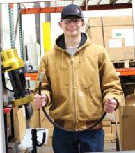 Hunter Sharkey shows off one of the hoses he made to be used for one of the products.