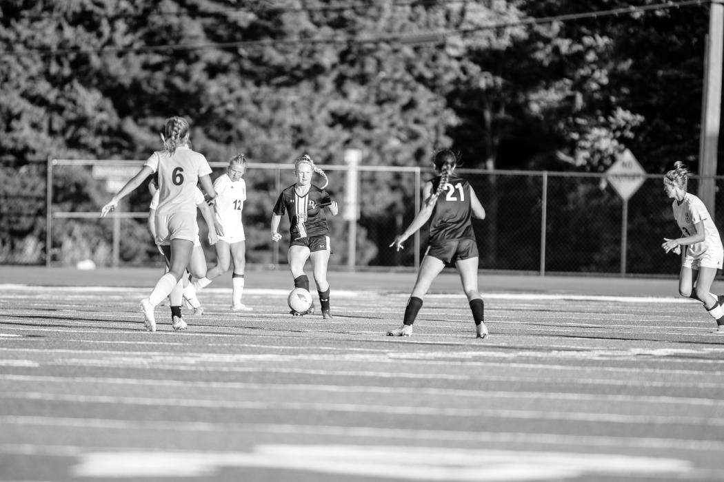 Ashlynn Stusse looks to pass to Emma Deacon against West Central Aug. 30. Photo by Peterman Sports Photography • photoman@iw.net