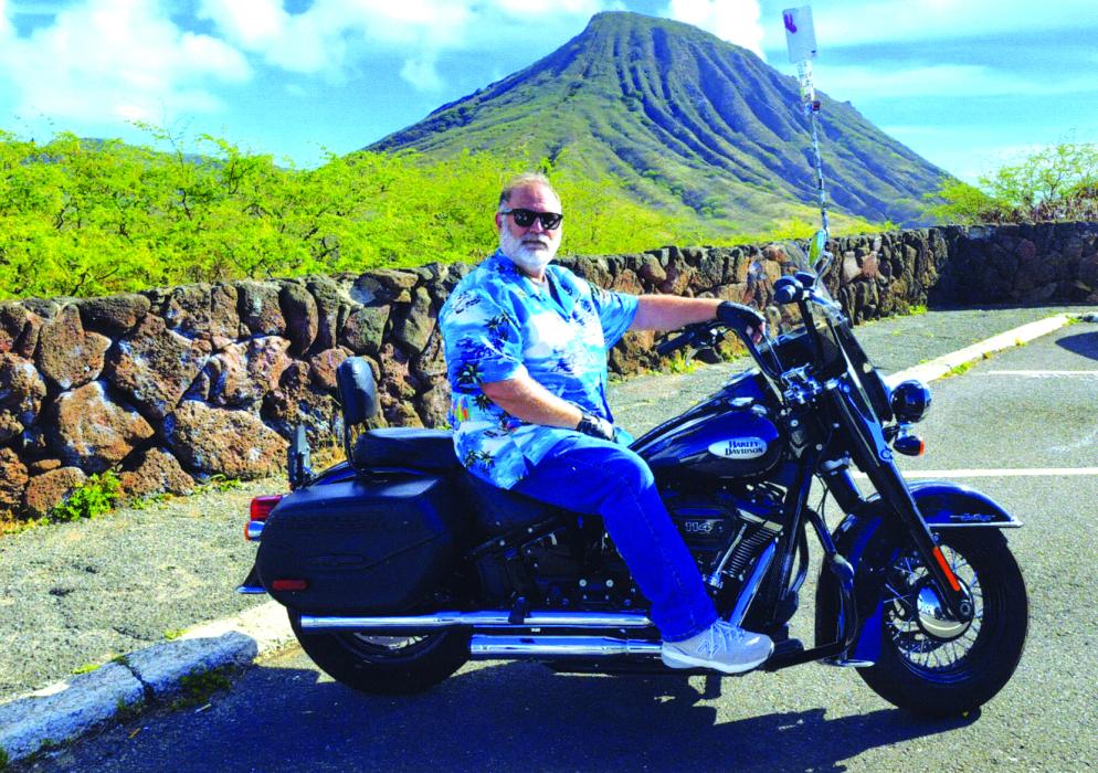 John Lokhorst completed his motorcycle tour of all 50 United States after 25 years. His last state was Hawaii. He’s pictured here with Hawaii’s scenic landscape behind him.  Submitted photo