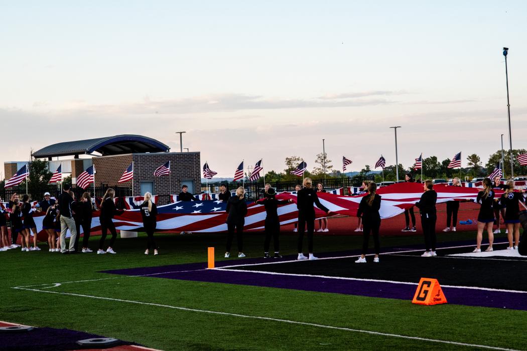 With a donation of flags from PreimerBankcard, the Dakota Valley field was decorated with flags around the stadium. Students helped bring a large American flag out onto the field for the National Anthem. Photo by Peterman Sports Photography • stevepeterman5@gmail.com