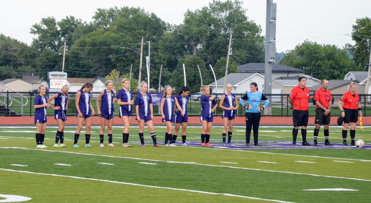 The girls soccer team lines up before the game begins against St. Thomas More Aug. 26. Pictured are, from left, Sophie Meyer, Ella Otten, Emma Deacon, Ella Chamberlain, Ashley Neeser, Ashlyn Stusse, Grace Meyer, Tyra Yi, Claire Hemmingsen, Lexi Stusse, Jae Bacan and three officials.