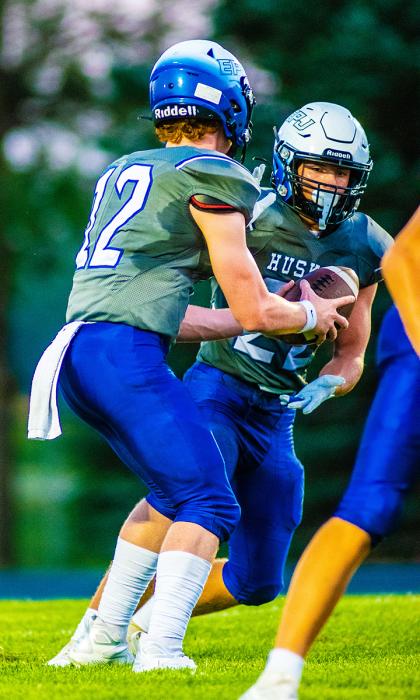 Noah McDermott hands the ball off to Lucas Hueser who scored 2 touchdowns against the Sioux Valley Cossacks Sept. 2. Photo by Peterman Sports Photography • photoman@iw.net