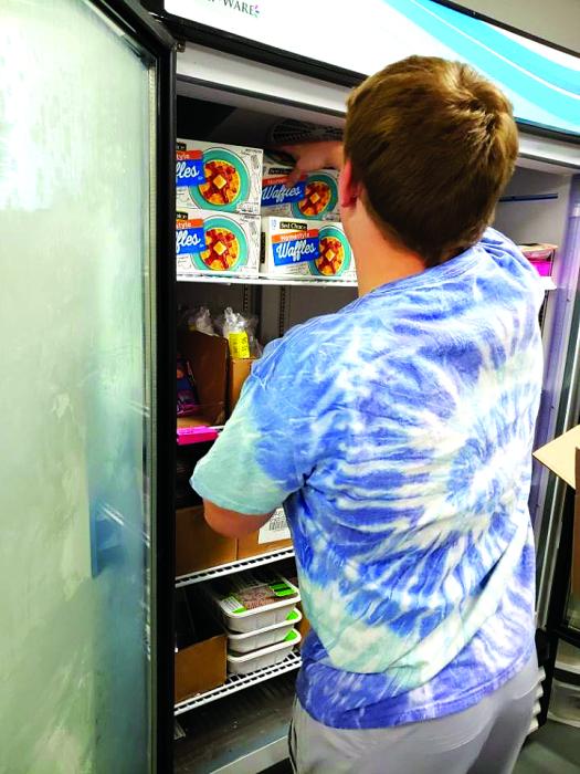 Students are helping out at the Elk Point Food Pantry every Tuesday to stock shelves as part of a new program. Submitted photo