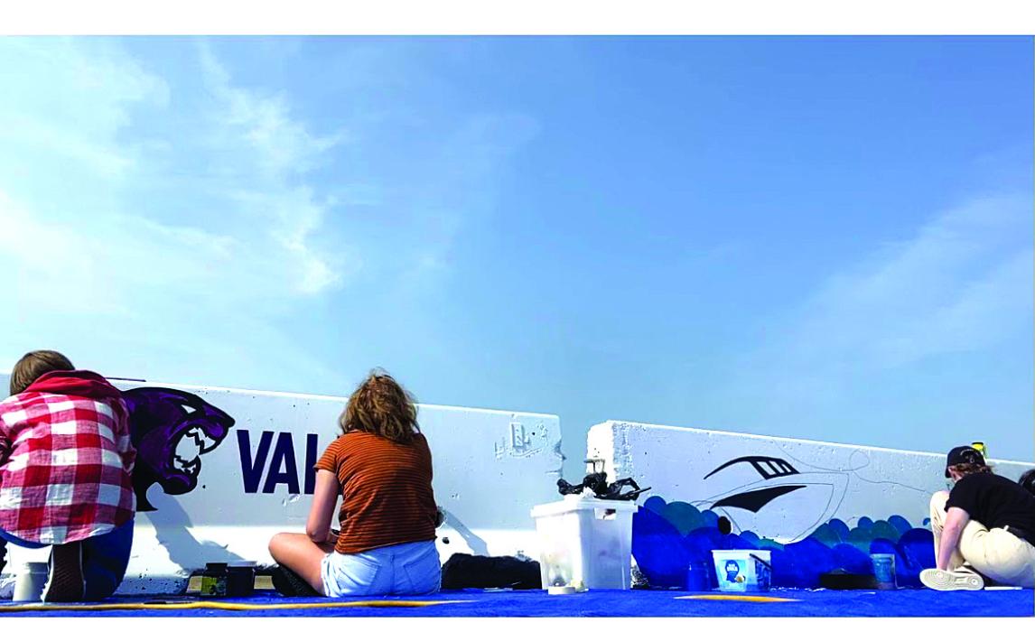 Jordan Pace, Kate Kenny and Kendy Delaney work on painting the barricades. Submitted photo