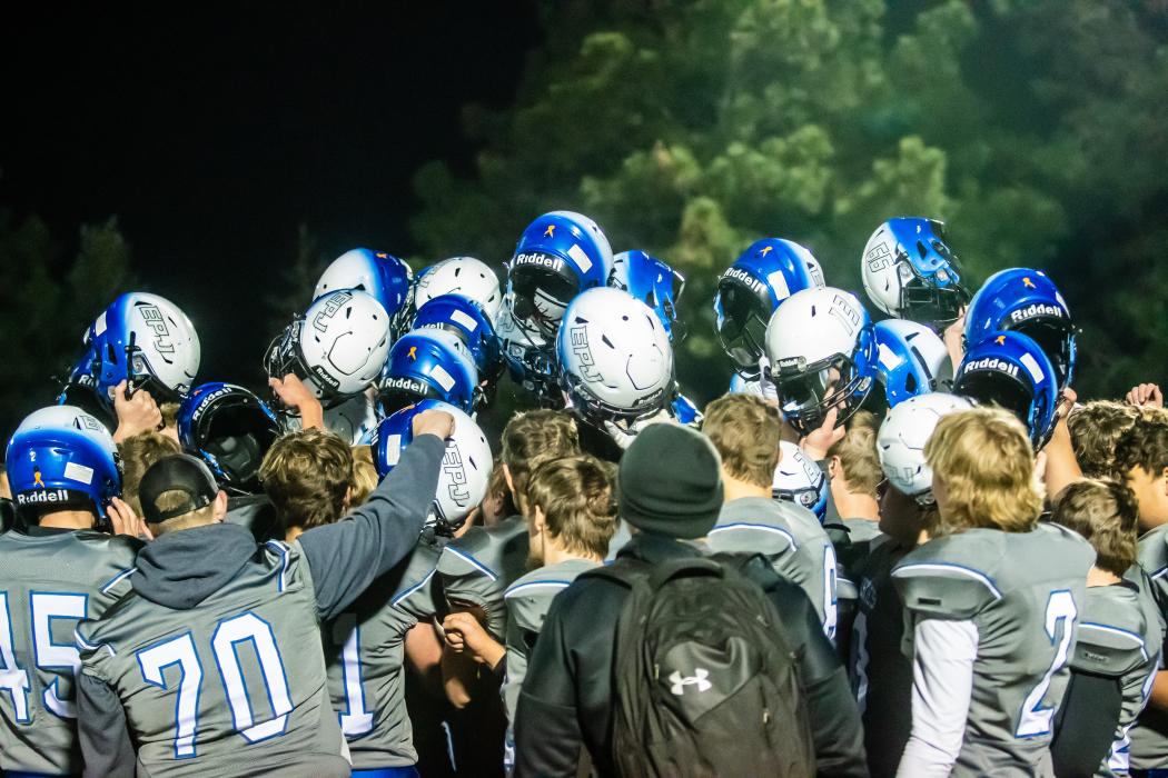 The Huskies have a celebratory team huddle at the end of the game. Photo by Peterman Sports Photography stevepeterman5@gmail.com