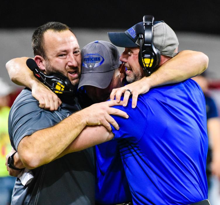 Elkpoint-Jefferson coaches JakeTerry, Heath Van-Roekel andJakeOtkin, hugincelebration astheHuskies secure thestate championship. Photo byPeterman Sports Photography •stevepeterman5@ gmail. com