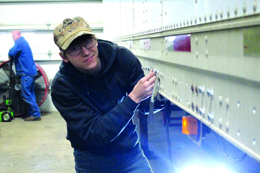 Hayden Smith places new bolts into the trailer to help reinforce the flooring. Photo by Beth Sherard-Hutcheson times1reporter@gmail.com
