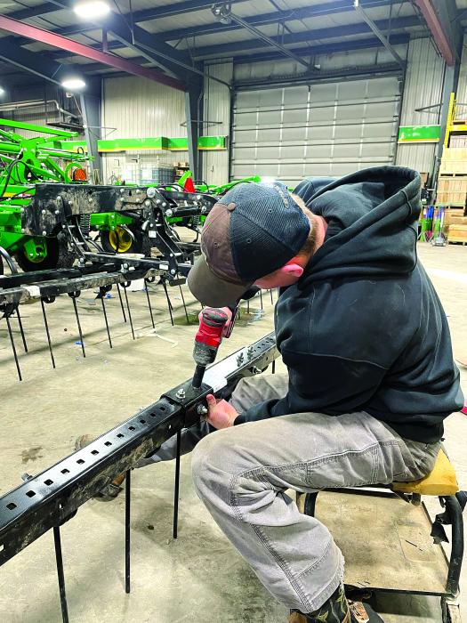 Aidan Suing puts together a harrow section. Suing and his coworkers are working on building a 2330 mulch finisher. Photo by Zach Erickson
