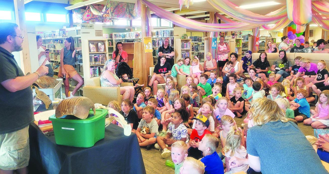 Educators from the Omaha Zoo demonstrate the importance of opposable thumbs when it comes to tying shoelaces at the North Sioux City library on Thursday, June 15. Photo by Kelly Riibe • times2reporter@gmail.com