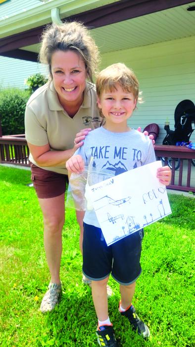 Jacob Gould,of Wynstone, stands with Park Manager Jody Moats at the Adams Homestead and Nature Preserve on Wednesday, June 15. Gould showed off his homemade candle and mulberry art work. Both were created during his time at the Pioneer Fun camp. Photos by Kelly Riibe • times2reporter@gmail.com