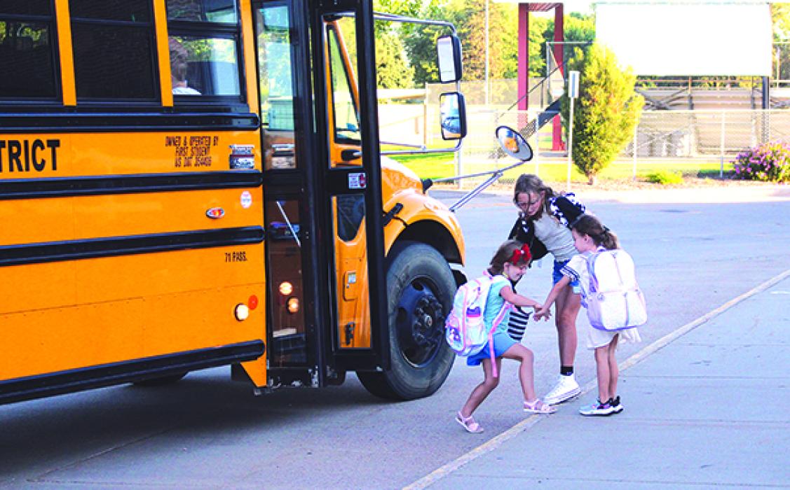 The first day of school for Elk Point-Jefferson was on Wednesday, Aug. 16. Family members and friends help each other while getting off the bus and heading to their classrooms to begin a new school year. (Top right) Brexlee gets ready for her first day of Kindergarten. Photo by Beth Hutcheson • times1reporter@gmail.com