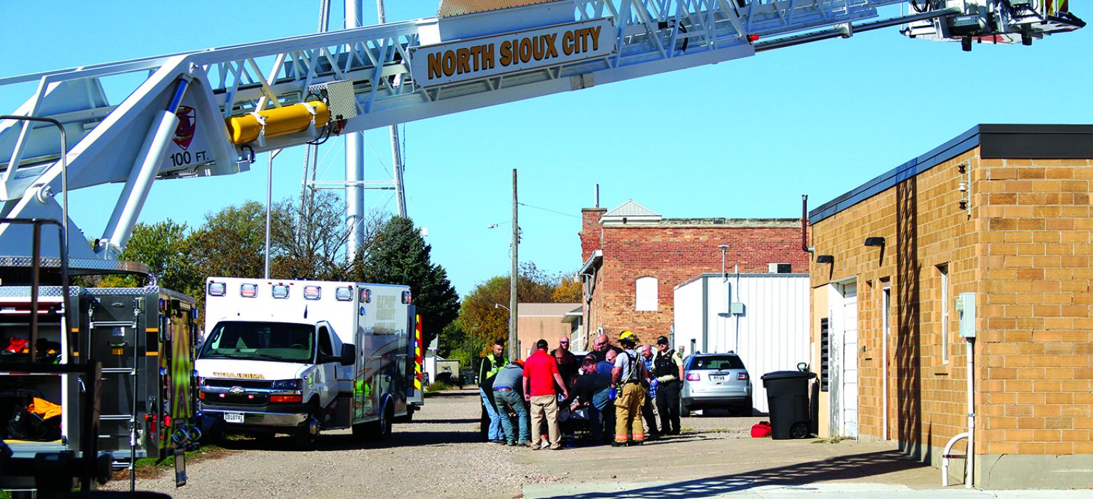 Emergency personnel responded to a rooftop accident in Elk Point Monday, Oct. 23. Shown here is the overwhelming response of mainly local volunteer responders from Elk Point and North Sioux City. The individual was safely removed from the roof and is being carefully lifted from a rescue basket onto a stretcher to be taken by ambulance to a helicopter for transport to an area hospital.  Photo by Beth Hutcheson • times1reporter@gmail.com