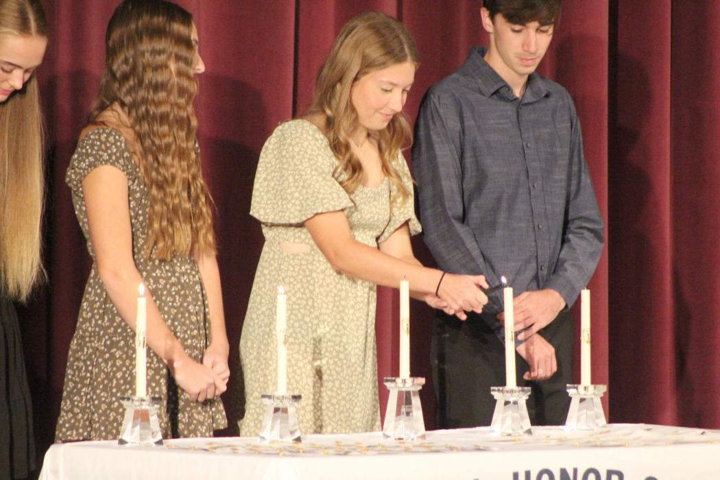 Josie Eckhardt, next to a few fellow Panther seniors, lights a candle during Dakota Valley’s NHS induction ceremony on Oct. 16. Pictured are, from left, Sophie Tuttle, Kyli Vaske, Josie Eckhardt and Brayden Karkalik. Submitted photo