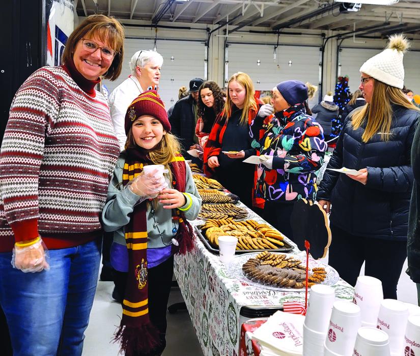 Liane Welte, North Sioux City Community Library Director, had a little helper as they passed out cookies and cocoa at the North Sioux City Holiday Light Parade Nov. 30.