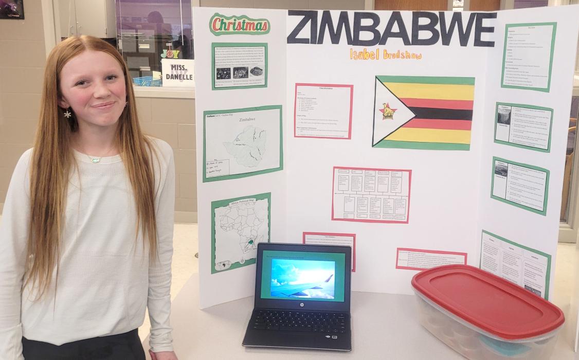Isabel Bradshaw, of Wynstone, did her project on Zimbabwe for the 7th Grade Culture Fair. She made mapopo (a popular Zimbabwe candy of sliced papaya cooked in sugar) to hand out at the fair. Photo by Kelly Riibe • times2reporter@gmail.com