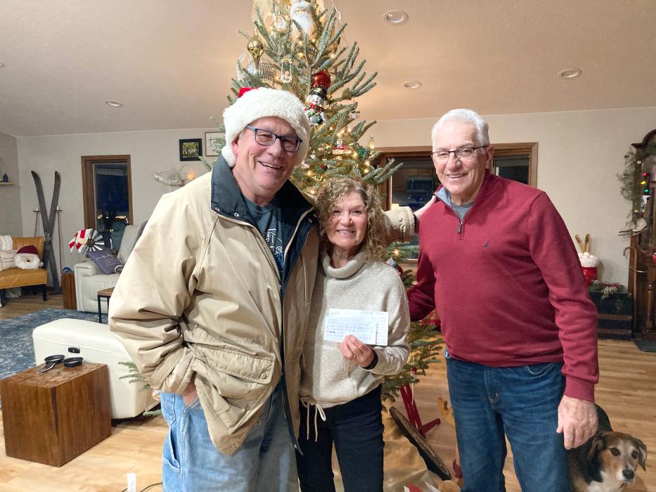 Jay Schenzel (left) also known as Santa Claus around the holiday season, presents Dawn and Dan Heaton with a check for $630 to benefit the Civil Bend Cemetery. Submitted photo