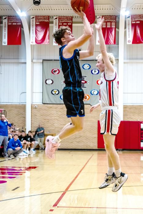 Carson Timmins shows his athletic ability as he jumps clear above his Vermillion defender on Jan. 16 in Vermillion. Photo by Peterman Sports Photography stevepeterman5@gmail.com
