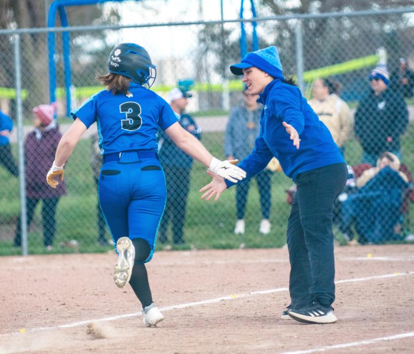 Head Coach Jessie Stouffer congratulates Regan Rasmussen on her homerun as she approaches home plate. Photo by Peterman Sports Photography • times1reporter@gmail.com