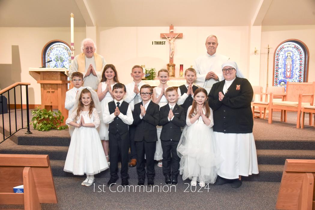 St. Teresa of Calcutta Catholic Church held its First Communion ceremonies on Sunday, April 28. Pictured are, from front left, Audrie Brandon, Kyler Hoefs, Broderick Jennett, Caiden Junck and Maddie Mousel; middle, Matias Smith, Ari Probasco, Greyson Becker, Cora Hunn, Joseph Kreber and Sister Julian; and back, Father Kevin Doyle and Deacon Joe Twidwell. Photo by Peterman Photography • stevepeterman5@gmail.com