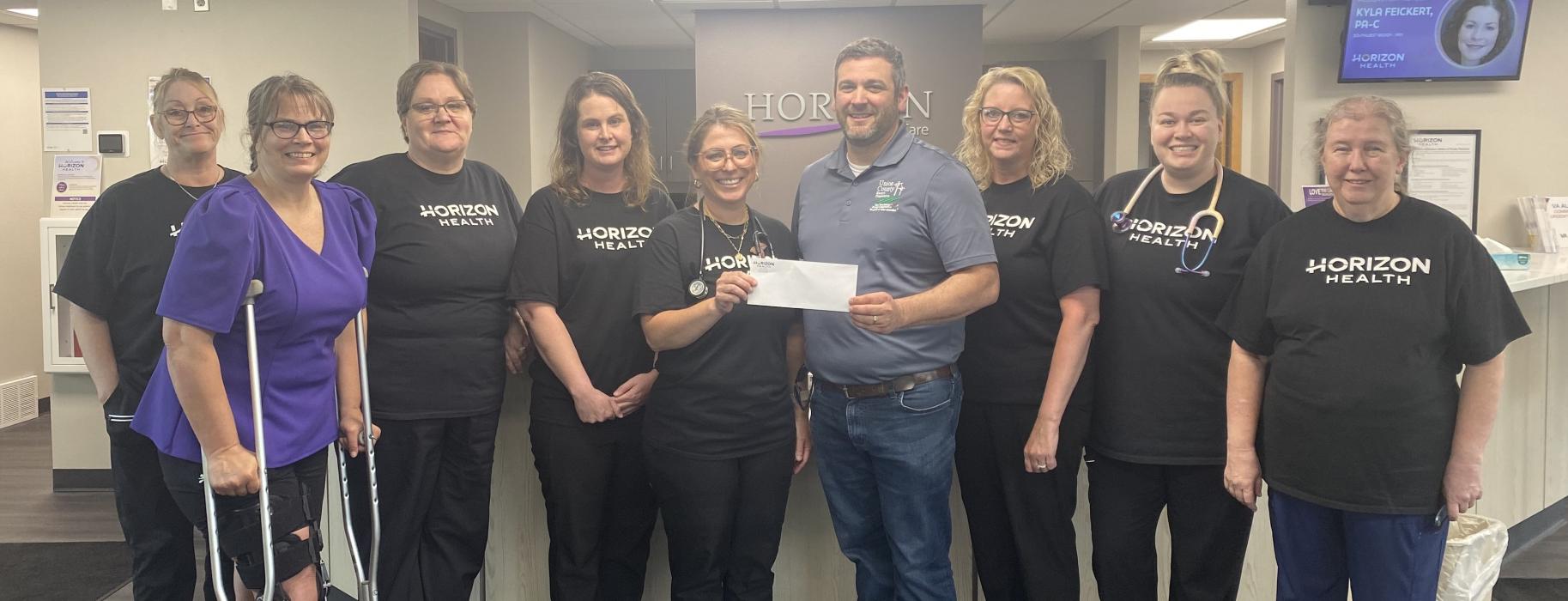 The staff of Horizon Health Elk Point received a grant from the Union County Electric Cooperative for a spot monitor that will help nurses better monitor patient’s respiration rates with up-to-the-minute readings. Staff members are pictured here, including Horizon Health Foundation Board Member Cheryl Havermann and Union County Electric Cooperative General Manager Matt Klein.
