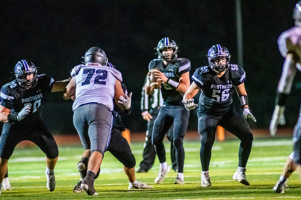 Drew Lukken looks for a receiver while Cooper Bernard (#70) and Jace Hutchinson (#56) provide protection versus SFC. Photo by Peterman Sports Photography • stevepeterman5@gmail.com