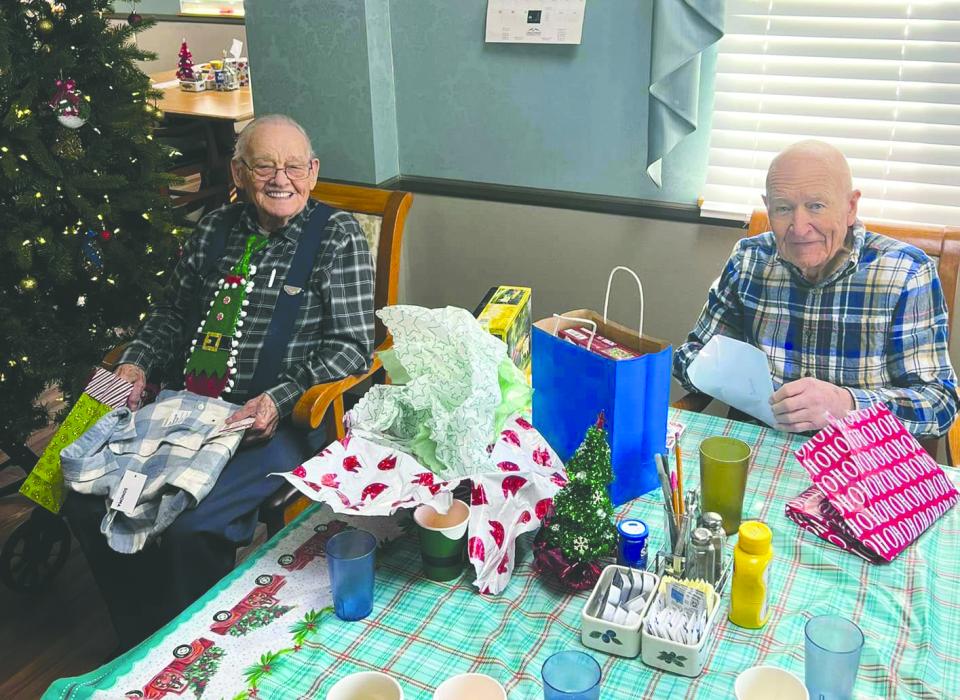Wel-Life residents smile as they open presents during the Christmas celebration. Submitted photo