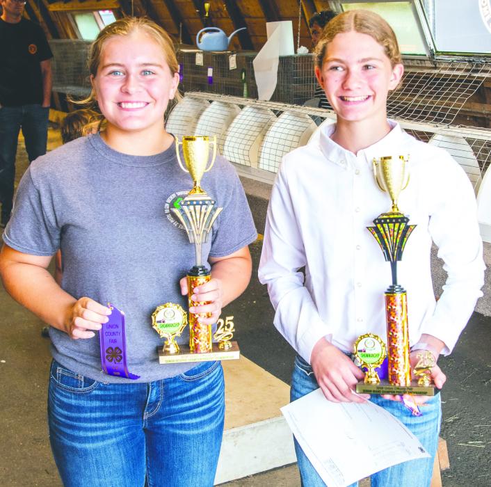 Regan Rasmussen, seen here on the left, poses with her Senior Showmanship award from the Fair.