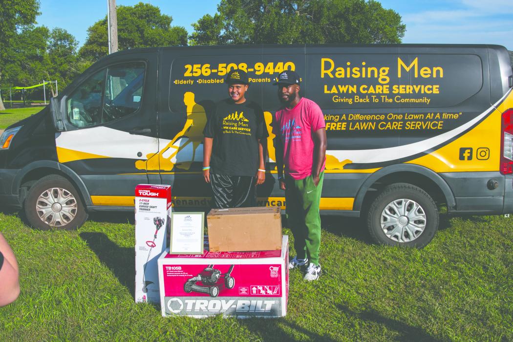 Kamryn Thiry getting his new lawn care items from Rodney Smith Jr for completing his lawn goal of mowing 50 yards for free this summer. Photo by Peterman Sports Photography • stevepeterman5@gmail.com