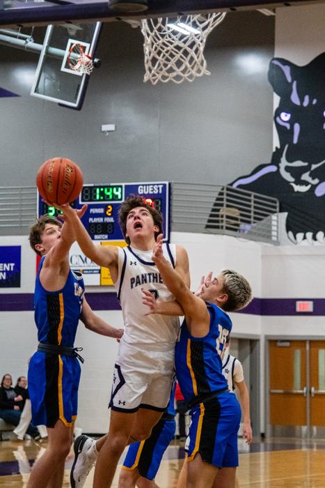 Luke Anema battles through two C-Hawks to get to the basket on December 19, 2025.