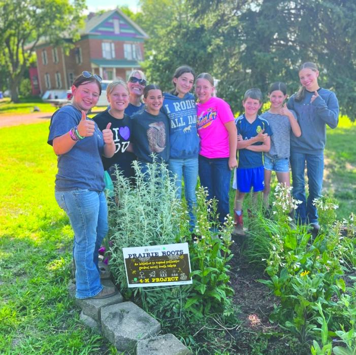 Members of the Brule Go Getters 4-H Club gather with club leader Jeanne Hanson around their completed “Prairie Roots” pollinator garden project at the Union County Museum in Elk Point. The native planting initiative is designed to establish pollinator-friendly habitats throughout SD. Submitted photo