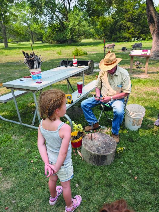 Corn cobs and turkey feathers made fun throwing toys for those attending the celebration at Adams Homestead on August 8th. Photo by Kelly Riibe • times2reporter@gmail.com