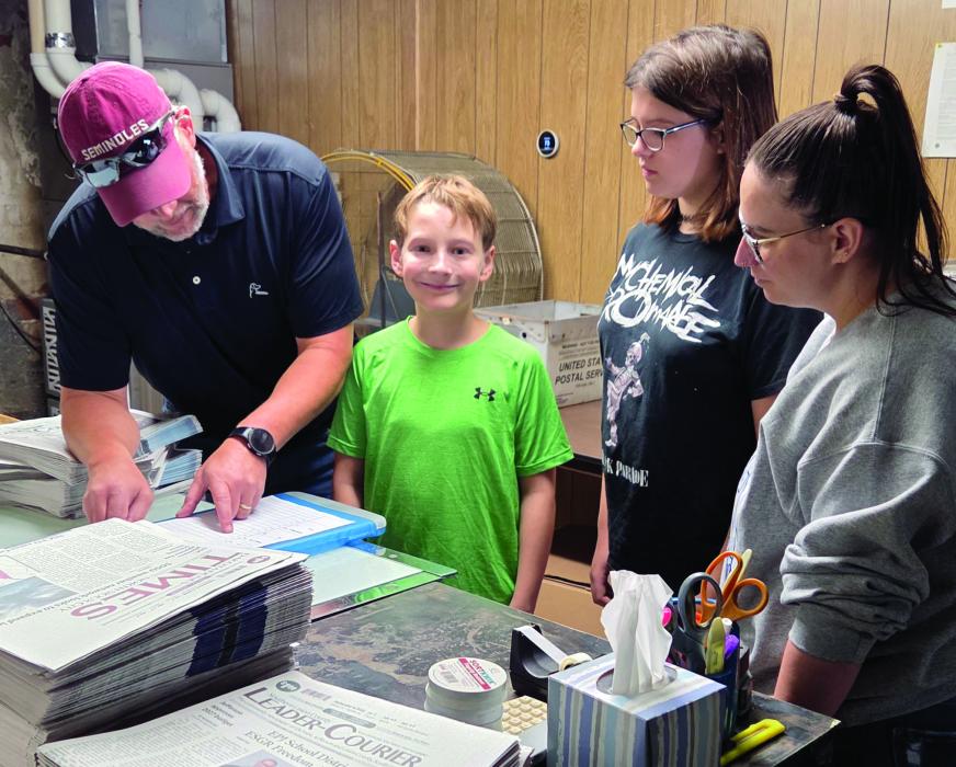 Monte Jost, co‑owner of the Leader-Courier, explains the paper’s single‑copy delivery route to EPJ Structured Learning Center students during a work‑experience visit. From left: Nathan Rogers, Clara Lambing and paraeducator Kim Convay. Photo by Shannon Jost • timesleader1@gmail.com
